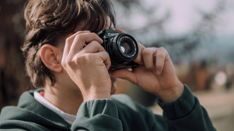 young man taking a photo with a canon ae-1