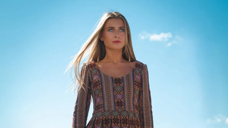 Open-air runway at Munich Fashion Week: A model on a catwalk against a clear blue sky.
