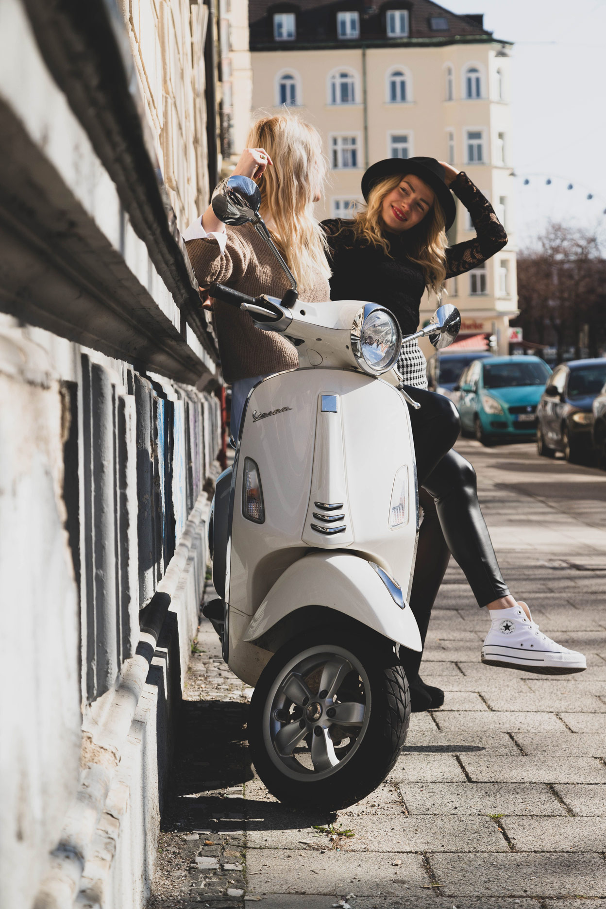 Two women on a scooter in a street