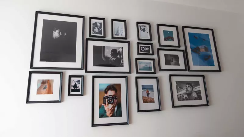 Self-designed photo wall with framed black and white and colour photos in black frames