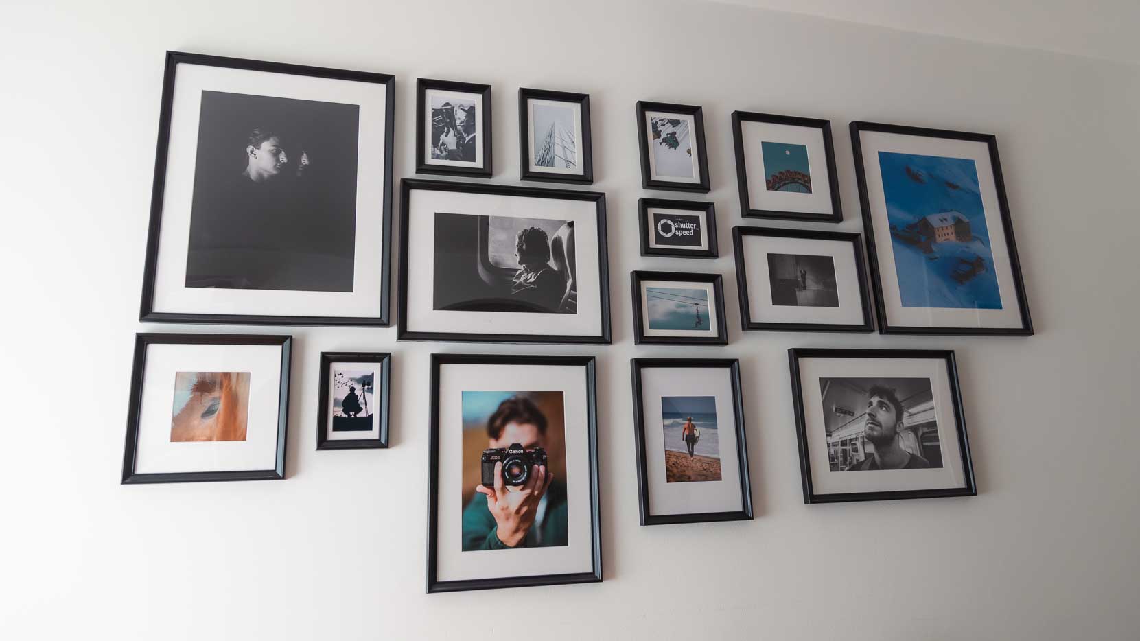 Self-designed photo wall with framed black and white and colour photos in black frames