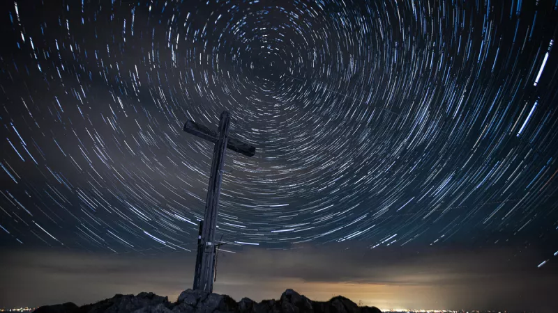 Star trails circling the summit cross on the Krottenkopf at night