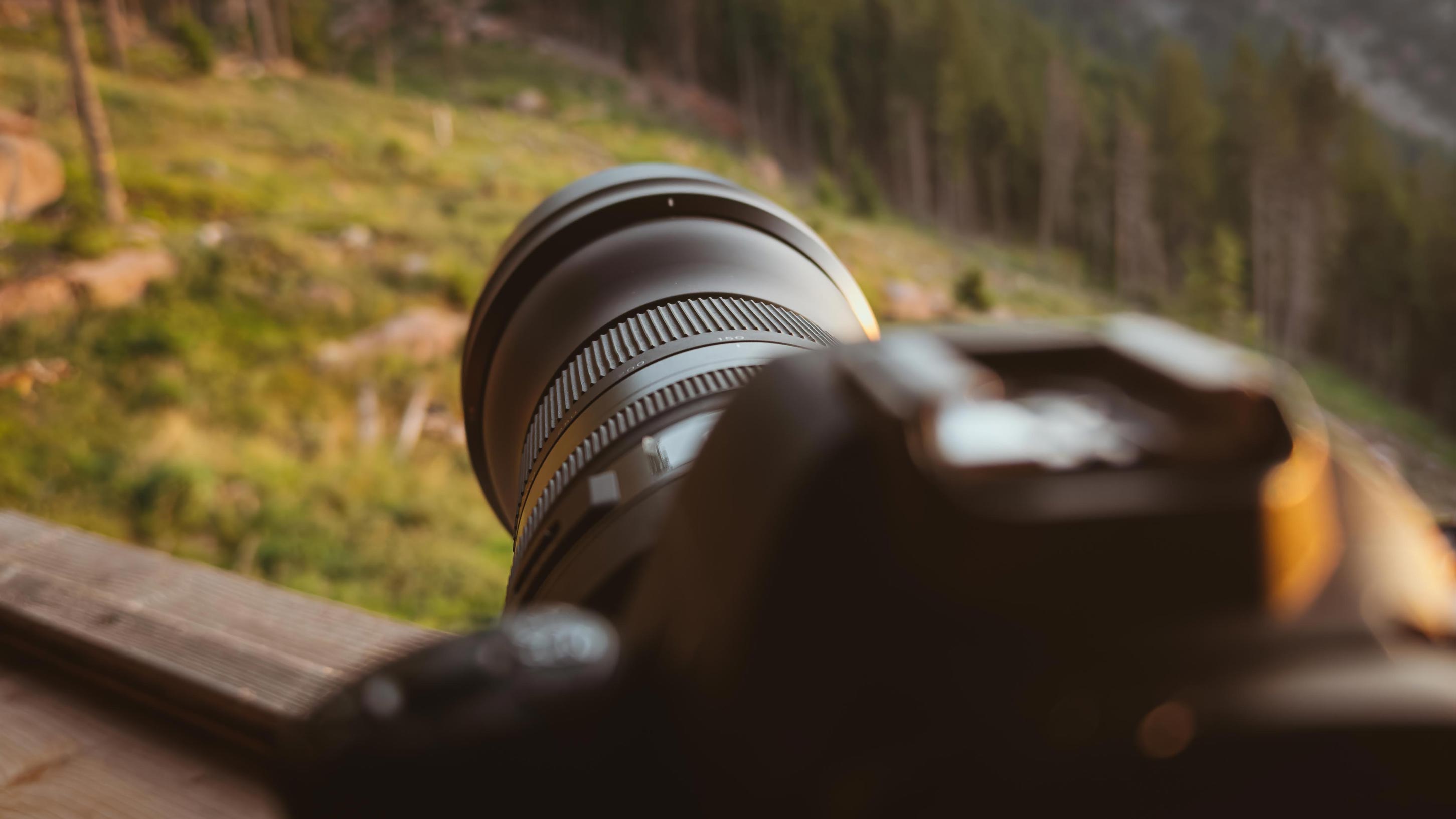 Camera with telephoto lens resting on the railing of a hunting hide in South Tyrol