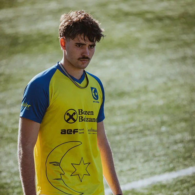 Portrait of a player in the yellow and blue kit, facing the camera on the pitch