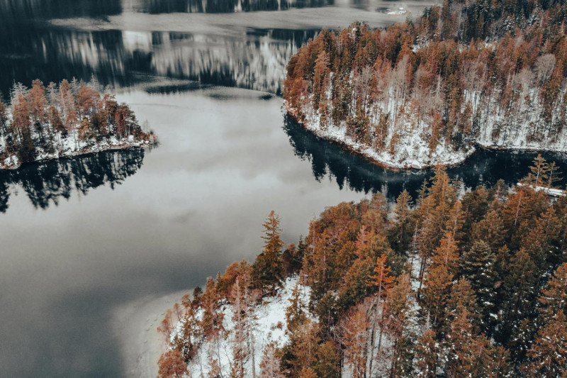 Drone footage of Lake Eibsee in winter with snow-covered trees